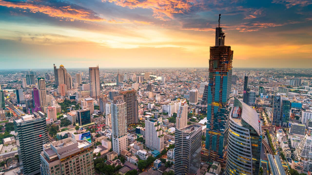 Aerial view of the Bangkok skyline at sunset with the Chao Phraya River